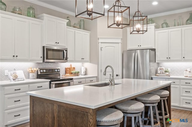 6319 Drexel Loop, Temple, TX 76502 - kitchen featuring stainless steel appliances, tasteful backsplash, a center island with sink, crown molding, and light countertops
