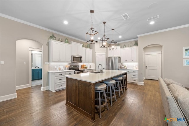 6319 Drexel Loop, Temple, TX 76502 - kitchen with stainless steel appliances, arched walkways, a center island with sink, a breakfast bar area, and light countertops