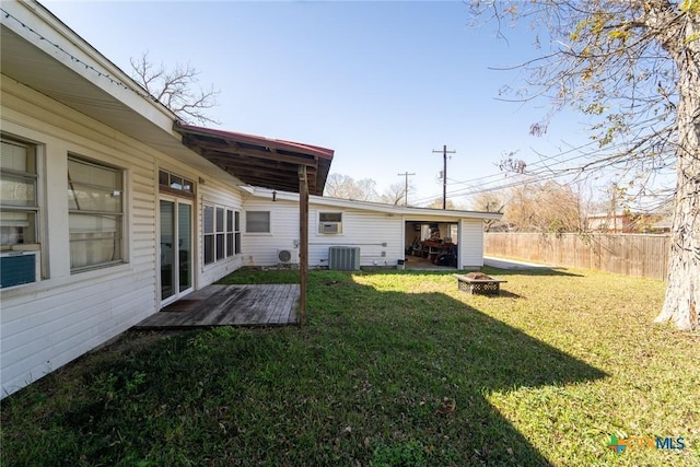 view of yard with central AC unit and an outdoor fire pit