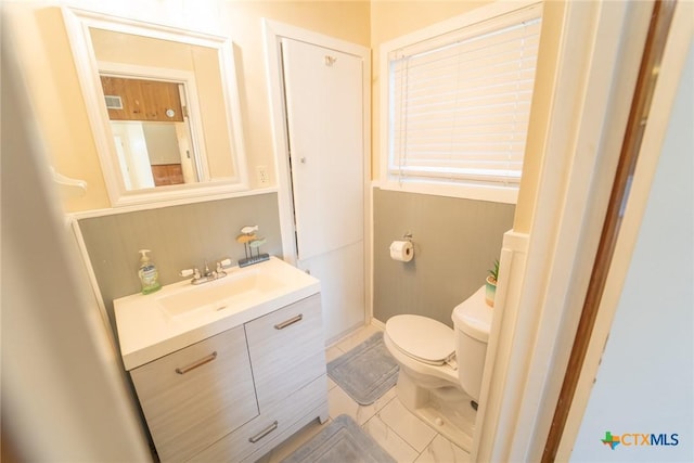 bathroom featuring tile patterned floors, vanity, and toilet