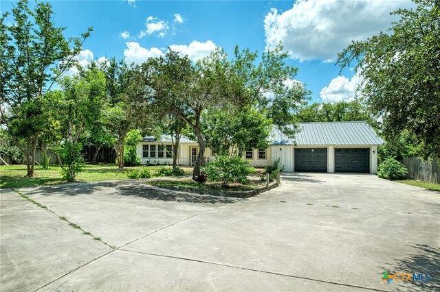 1606 Lone Man Mountain Rd, Wimberley, TX 78676 - view of front of home featuring concrete driveway, a garage, fence, and metal roof