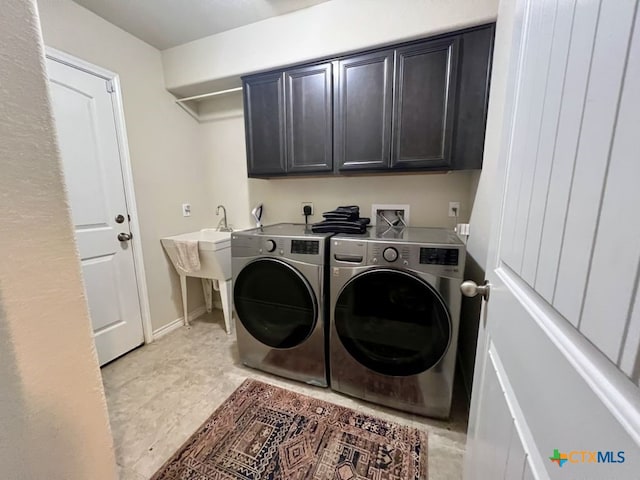 laundry room with separate washer and dryer and cabinets