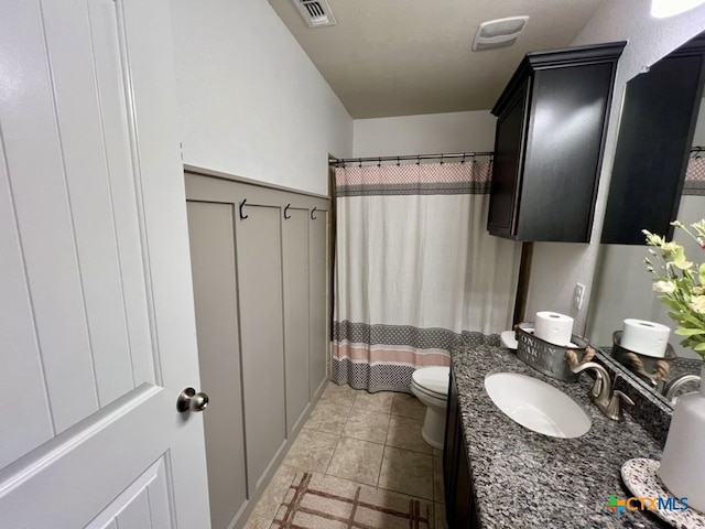 bathroom with tile patterned flooring, vanity, toilet, and walk in shower