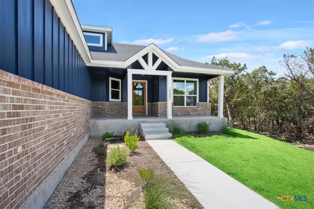 doorway to property with a yard and a porch