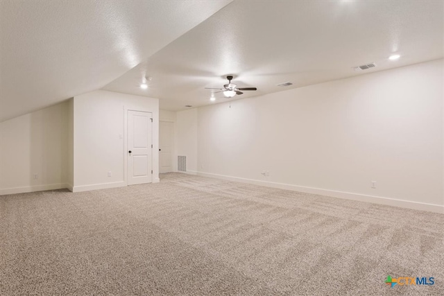 additional living space with a textured ceiling, carpet floors, ceiling fan, and vaulted ceiling