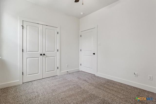 unfurnished bedroom featuring ceiling fan, a closet, and carpet