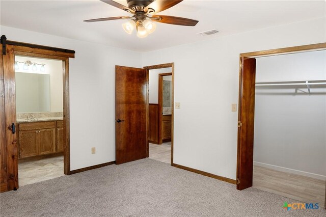 unfurnished bedroom with baseboards, light carpet, visible vents, and a closet