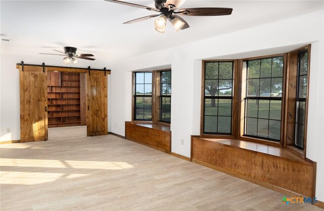 doorway to outside featuring light wood finished floors, a wainscoted wall, and wooden walls