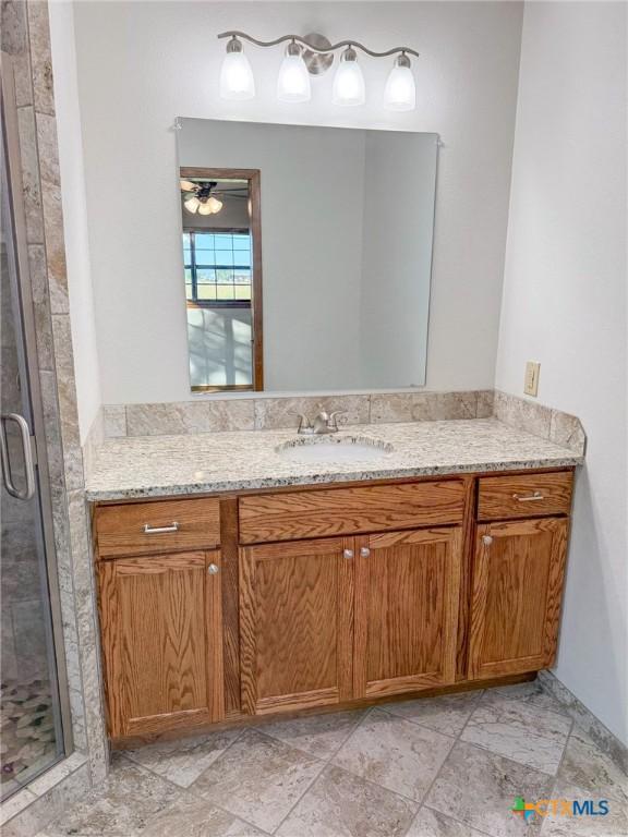 full bathroom featuring toilet, vanity, and a stall shower