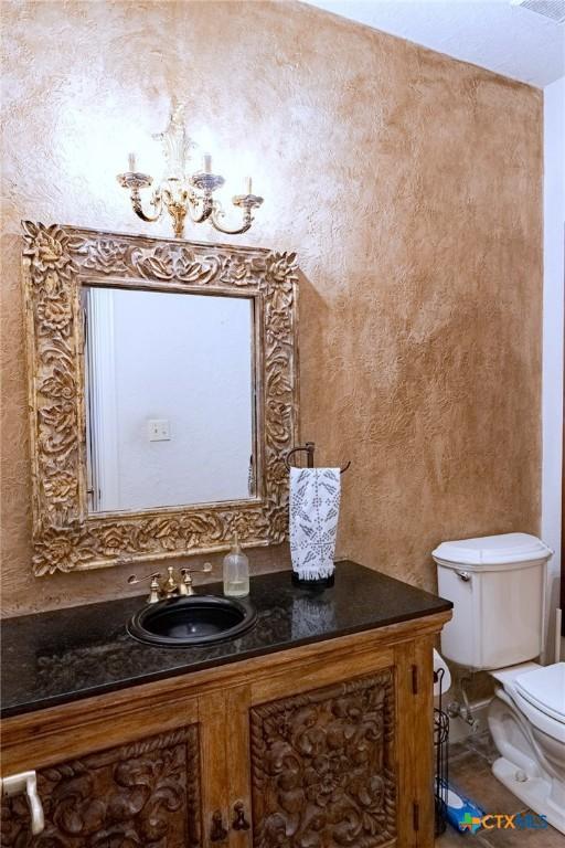 bathroom featuring toilet, tile patterned floors, a chandelier, and vanity