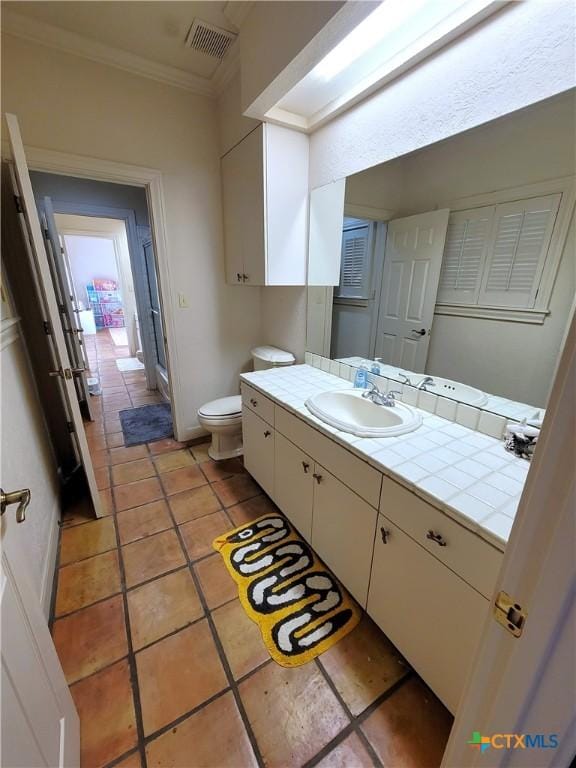 bathroom featuring tile patterned flooring, toilet, vanity, visible vents, and ornamental molding