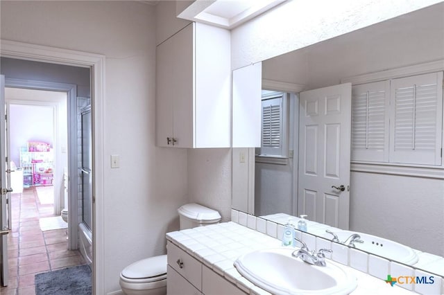 bathroom featuring a textured wall, tile patterned flooring, toilet, bathing tub / shower combination, and vanity