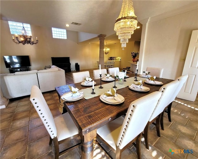 dining room with an inviting chandelier, visible vents, ornamental molding, and ornate columns