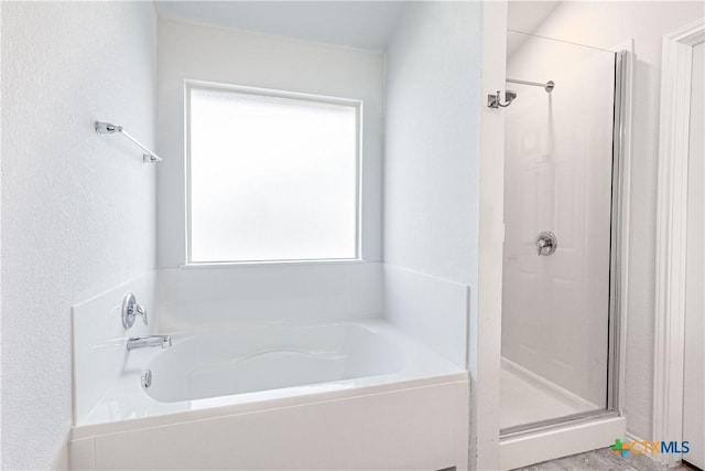 bathroom featuring plus walk in shower and a wealth of natural light