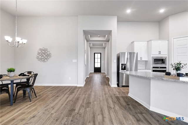 513 Foxbrook Way, Cibolo, TX 78108 - kitchen with stainless steel appliances, light wood-style floors, white cabinetry, baseboards, and a chandelier