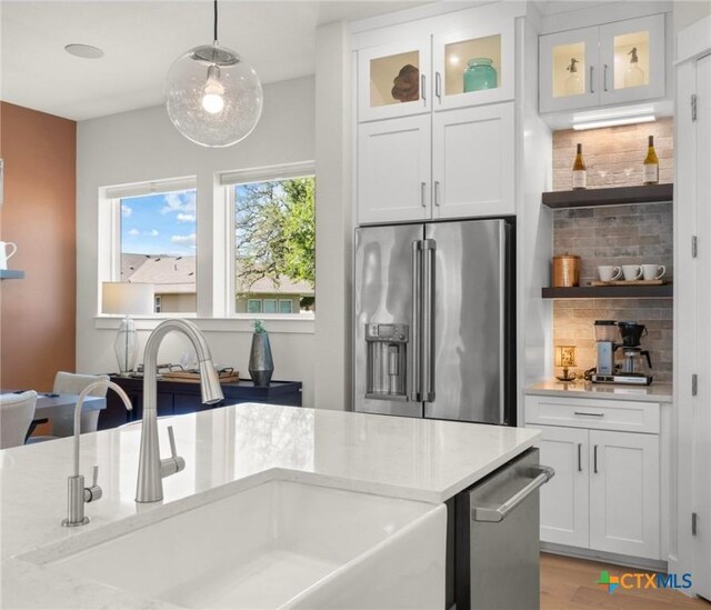 105 Monterey Oak Trl, Georgetown, TX 78628 - kitchen with appliances with stainless steel finishes, a sink, backsplash, and white cabinetry