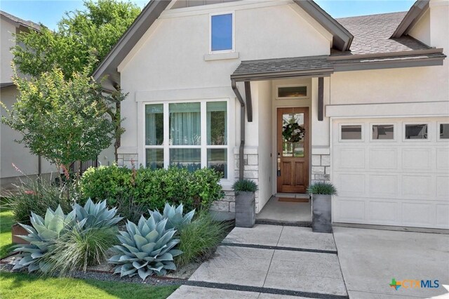 105 Monterey Oak Trl, Georgetown, TX 78628 - property entrance with stucco siding, a garage, a shingled roof, and stone siding