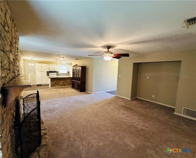 225 Monterrey Dr, Victoria, TX 77904 - unfurnished living room featuring ceiling fan with notable chandelier, visible vents, and light colored carpet