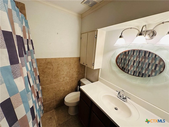 225 Monterrey Dr, Victoria, TX 77904 - bathroom with visible vents, toilet, ornamental molding, vanity, and tile walls