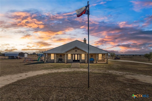 view of front of property featuring a playground and a lawn