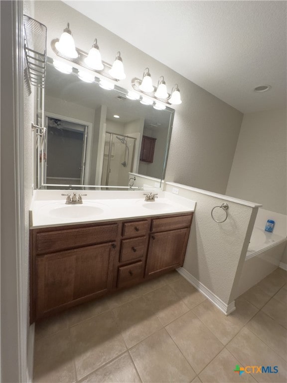 bathroom with vanity, a textured ceiling, tile patterned flooring, and a shower with door