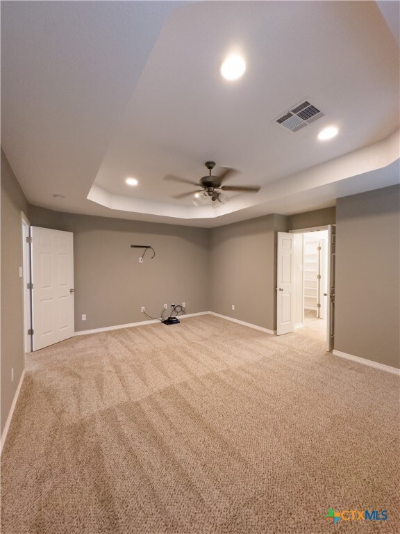 basement featuring light colored carpet and ceiling fan