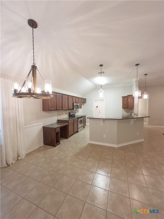 kitchen with sink, appliances with stainless steel finishes, light tile patterned floors, decorative light fixtures, and vaulted ceiling