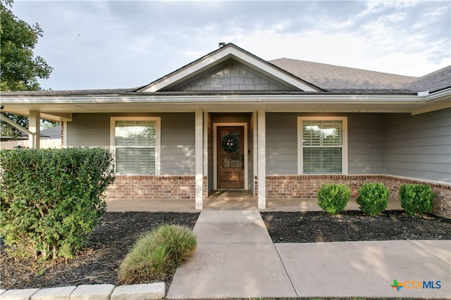 view of exterior entry with covered porch