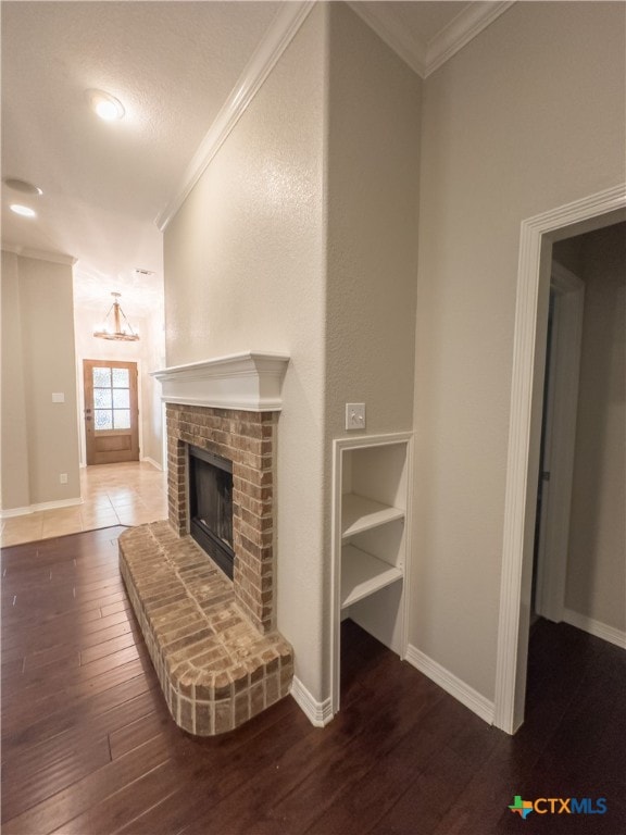 unfurnished living room featuring hardwood / wood-style floors, a fireplace, and ornamental molding