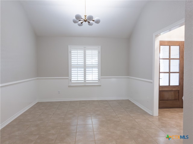 spare room with a wealth of natural light, lofted ceiling, light tile patterned floors, and a notable chandelier