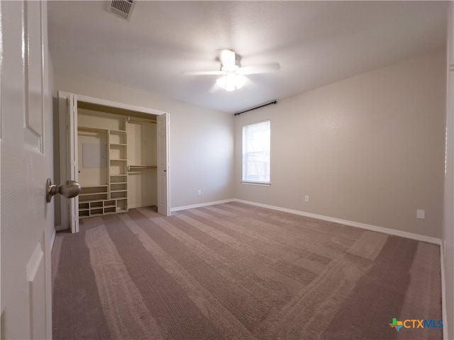 unfurnished bedroom with carpet flooring, ceiling fan, a walk in closet, and a closet