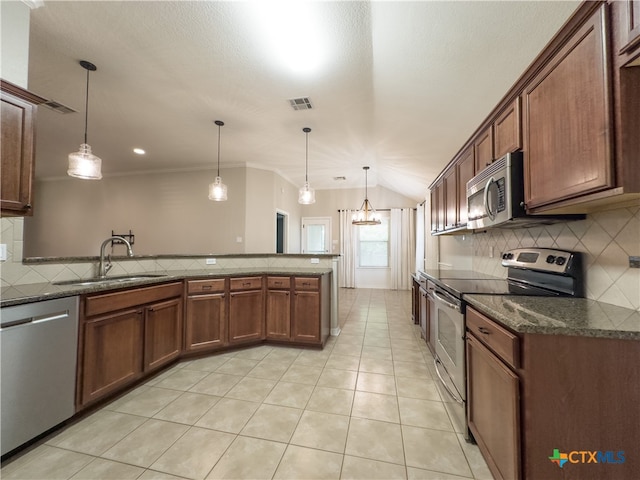 kitchen with sink, appliances with stainless steel finishes, backsplash, decorative light fixtures, and a chandelier