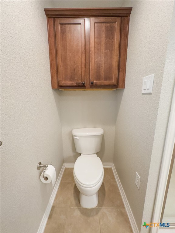 bathroom featuring toilet and tile patterned floors