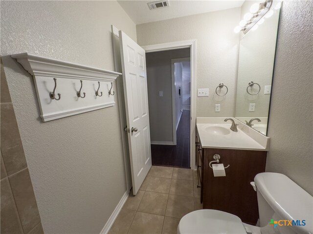 bathroom featuring vanity, tile patterned flooring, and toilet