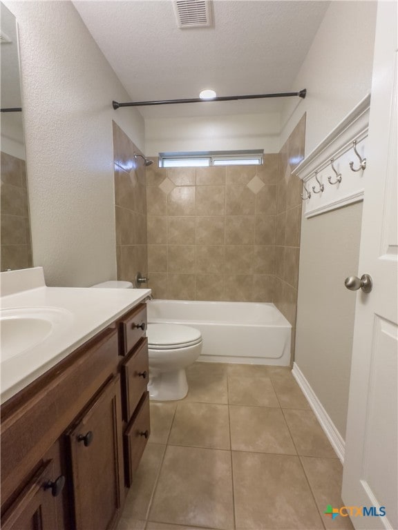 full bathroom with toilet, tile patterned flooring, tiled shower / bath, a textured ceiling, and vanity