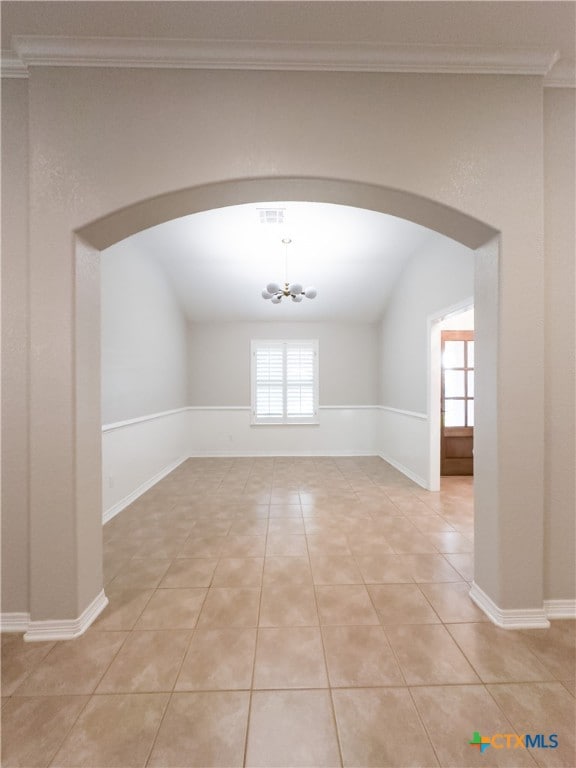 unfurnished room with light tile patterned flooring, an inviting chandelier, and lofted ceiling