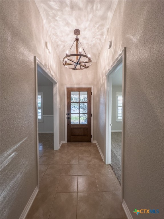 doorway featuring a chandelier and tile patterned flooring