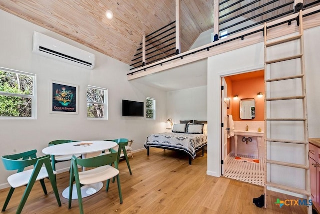 200 W Meadow Ln, Wimberley, TX 78676 - bedroom with a wall mounted air conditioner, wooden ceiling, a barn door, baseboards, and wood finished floors