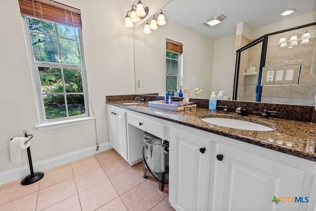 200 W Meadow Ln, Wimberley, TX 78676 - full bathroom with double vanity, a stall shower, tile patterned floors, and baseboards