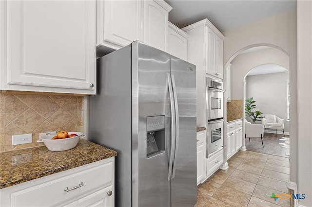 3312 Cortes Pl, Round Rock, TX 78665 - kitchen with appliances with stainless steel finishes, decorative backsplash, white cabinetry, and dark stone countertops