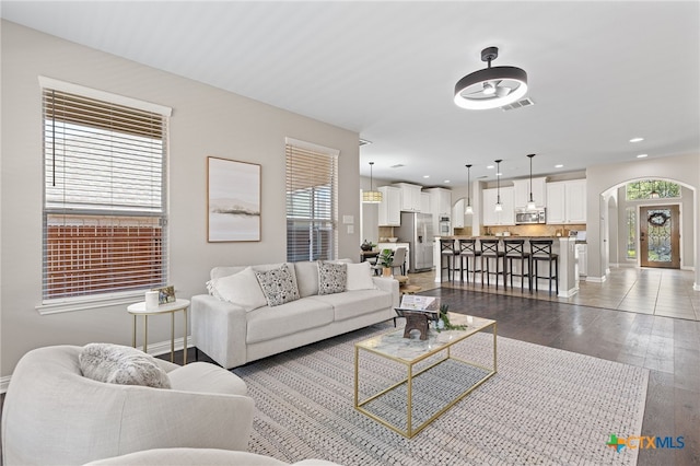 3312 Cortes Pl, Round Rock, TX 78665 - living room featuring healthy amount of natural light, dark wood-type flooring, arched walkways, baseboards, and recessed lighting