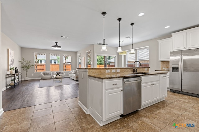 3312 Cortes Pl, Round Rock, TX 78665 - kitchen featuring stainless steel appliances, a sink, a center island with sink, decorative backsplash, and decorative light fixtures