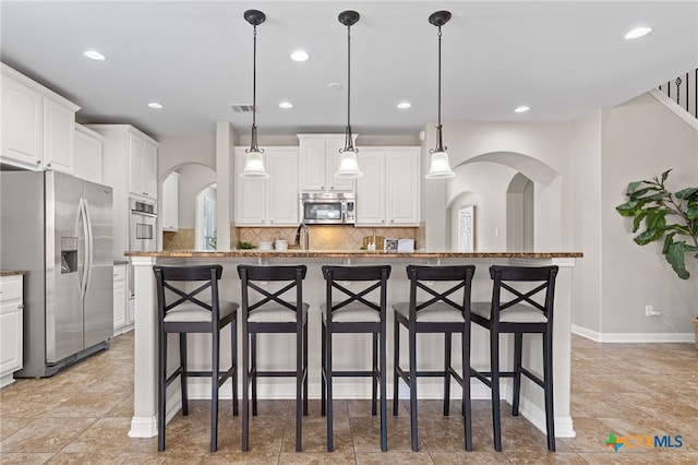 3312 Cortes Pl, Round Rock, TX 78665 - kitchen featuring stainless steel appliances, a breakfast bar, white cabinetry, tasteful backsplash, and recessed lighting