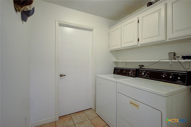 laundry room featuring cabinets, washer and dryer, and light tile patterned flooring