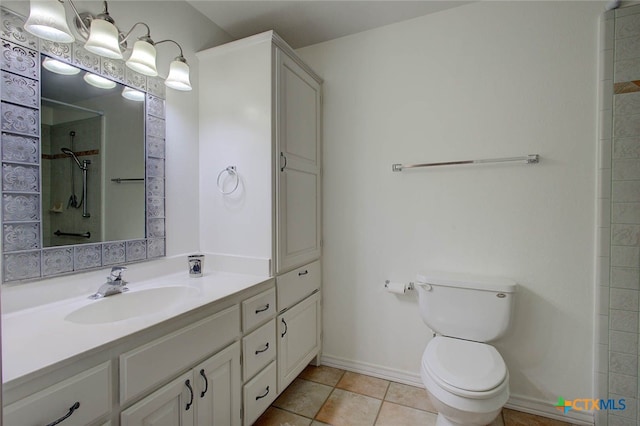 bathroom featuring vanity, tile patterned floors, toilet, and a tile shower