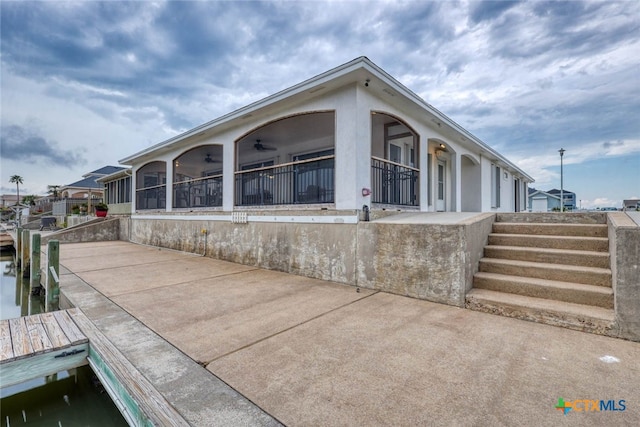 view of property exterior with a dock and a patio area