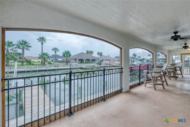 view of patio / terrace with ceiling fan and a water view