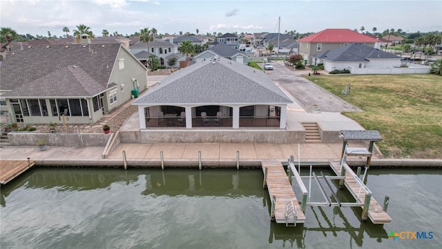 dock area with a yard, a water view, and a patio area