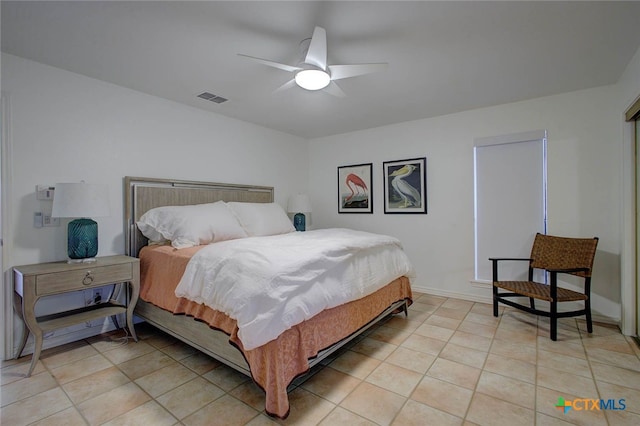 tiled bedroom featuring ceiling fan