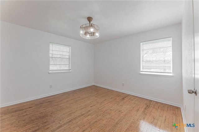 empty room with light wood finished floors and baseboards